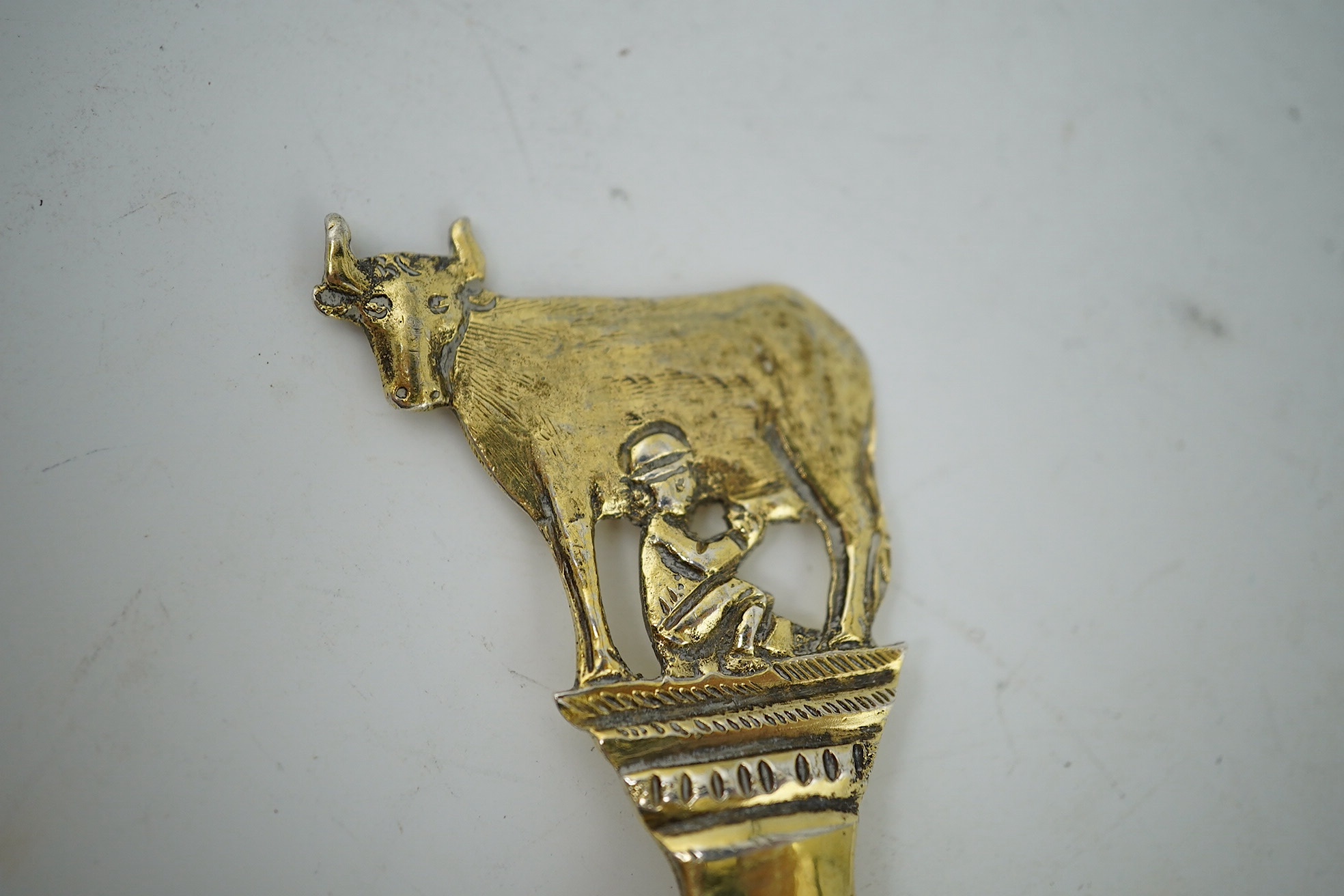 An early 17th century Dutch silver gilt spoon, the terminal modelled as a cow being milked, 17.5cm long, 47g. Condition - fair